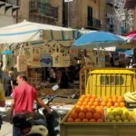Capo Market in Palermo with colourful fruit stalls, oranges, lemons and traditional Sicilian souvenirs.